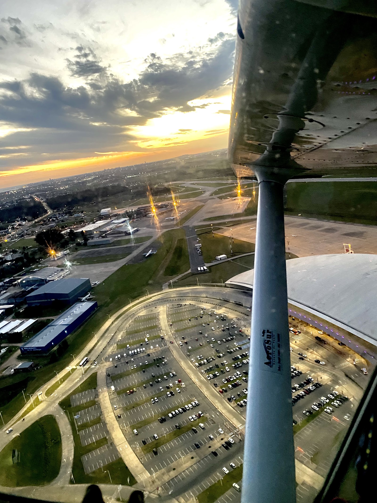 Vista aérea al atardecer sobre el aeropuerto y la costa, tomada por Time Flies